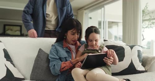 Parents, kid and relax with tablet on sofa for playing games, educational research and bonding