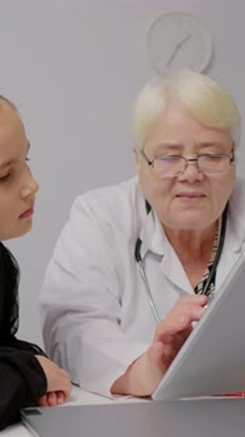 Doctor Explains Information to Child Patient Using Tablet