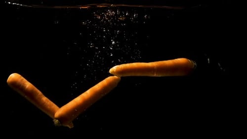 Fresh Orange Carrots Falling into Water