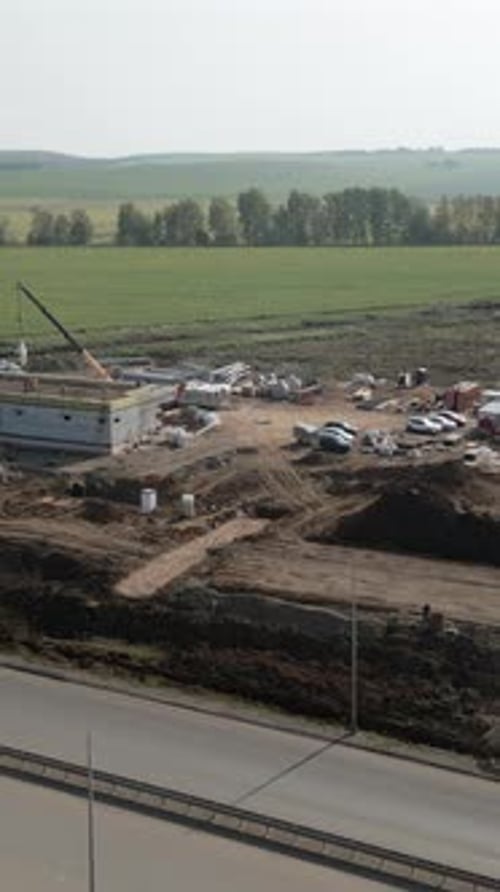 Building Construction Progressing Near Highway in Rural Landscape Clip