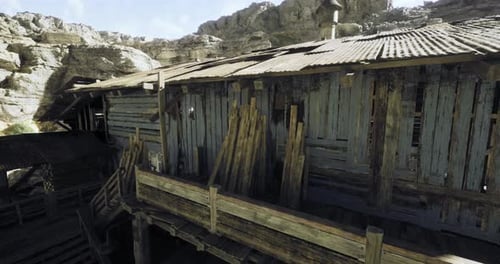 Rustic Wooden Structure Nestled Among Rocky Terrain Under Clear Skies