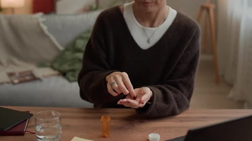 Woman Takes Pills with Water in Cozy Home