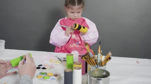 Child and Adult Painting Paper Tubes at Table