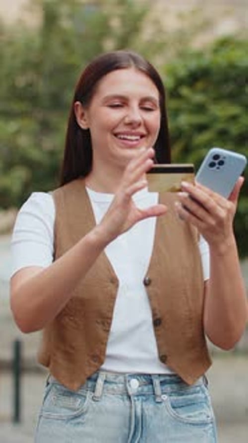 Happy Caucasian Woman Using Credit Card Smartphone While Purchases Online Shopping on City Street