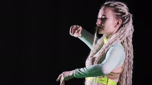 Portrait d'une belle fille avec des dreadlocks. Une danseuse de go-go dans un costume sexy la fait bouger magnifiquement