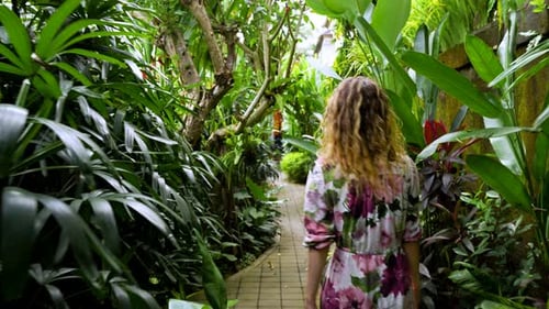 Woman walking in lush tropical garden