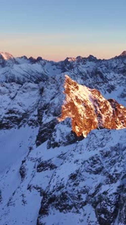 Majestic sunset over snow-covered Alps in vertical view