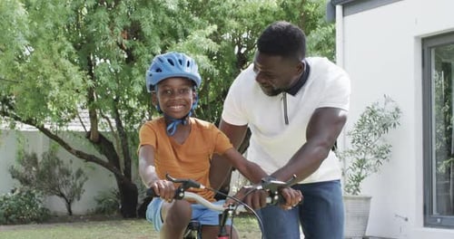 Father Teaching Son to Ride a Bike Outdoors