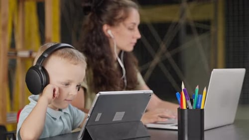 Child and Adult Working with Technology Indoors