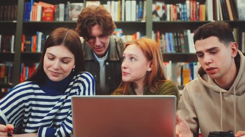 Friends Collaborating on Project in Library