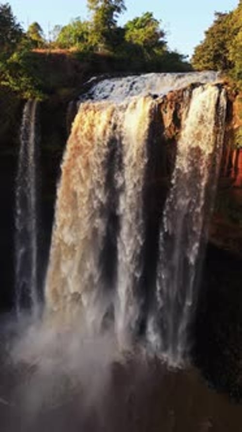 Flow of water runs down from waterfall drone point view.