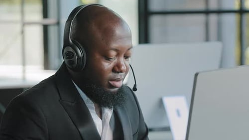 Vielbeschäftigter Adult Manager Marketingspezialist Softwareingenieur trägt Kopfhörer bei der Arbeit am Laptop