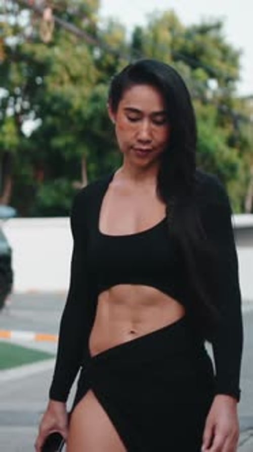 Stylish Young Woman Poses in Black Outfit Outdoors