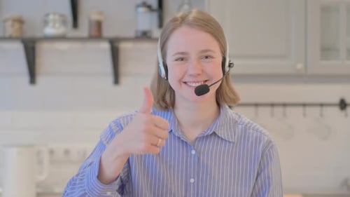 Thumbs Up by Young Woman with Headset in Call Center