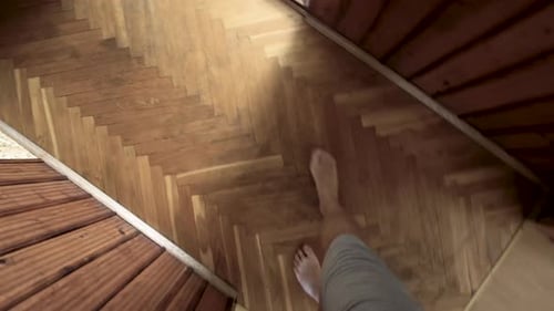 Caucasian men walking on the old wooden floor and up the stairs.