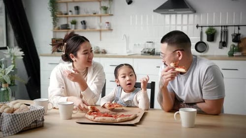 Family Enjoys Pizza Together in Modern Kitchen