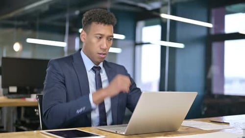 Young Adult Coughs While Working at Laptop