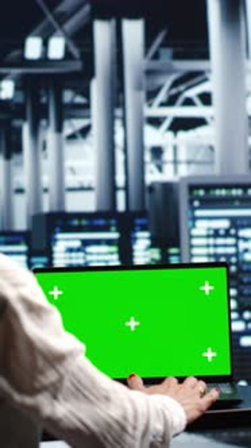 Typing on Green Screen Laptop in Modern Office