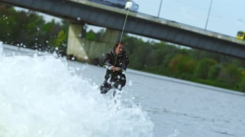 Young Man Riding Wakeboard on Summer River. Entertainment on Water of City