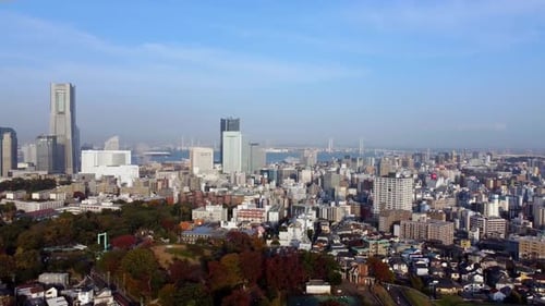 Daytime aerial view of a bustling cityscape with skyscrapers and clear skies