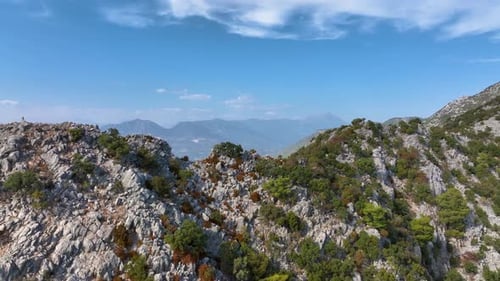 Majestätische Berggipfel erheben sich dramatisch und zeigen ein weitläufiges Tal und ferne Gebirgszüge unter einem