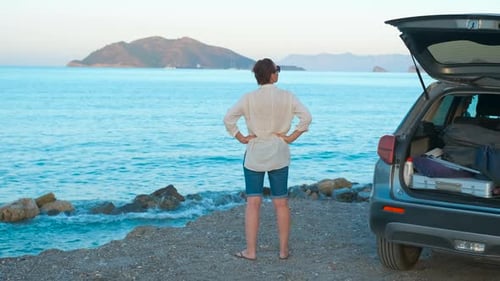 Woman By Parked Car Against Sea