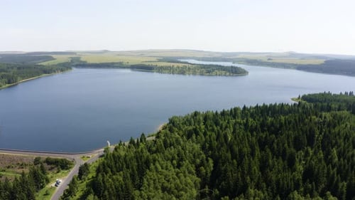 Luftbild von einer Drohne: Ein See in einer ländlichen Gegend an einem sonnigen Tag