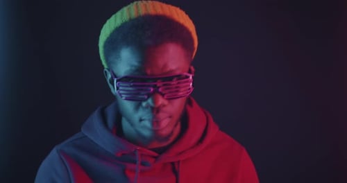 African American Man Dancing on Dark Background Wearing Illuminated Glasses