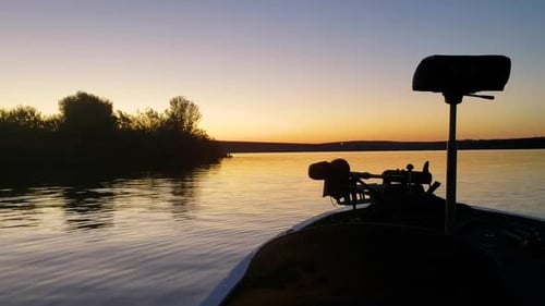 Colorful Sun Rise in Bass Fishing Boat on Calm Beautiful Lake, Ripples in the Water and Trees in the