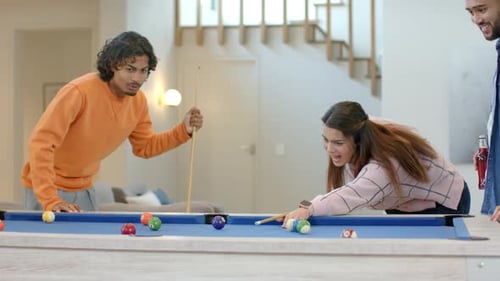 After shot scattering, diverse friends hugging and laughing in bright tops at blue-felt pool table