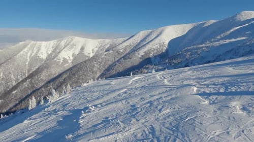 Aerial View of Empty Ski Resort in Sunny Winter Mountains Background