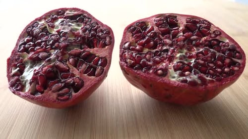 Rotating pomegranate fruit and seeds, top view, 4K