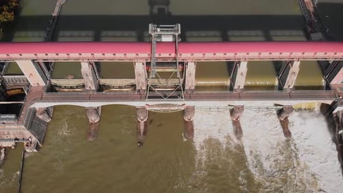 Mächtiger Wasserstrom fließt durch geöffnete Tore am Flussdamm