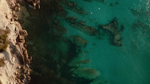 Aerial drone turquoise coastline rocky shore crystal clear sea cinematic top view summer aerials