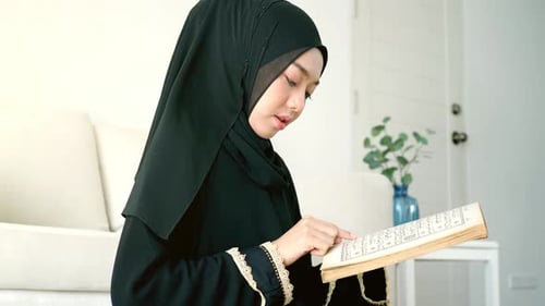 Portrait of Asian Muslim man - women reciting Surah al-Fatiha passage of the Qur'an, in a daily pray