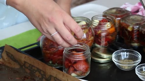 Preparing Marinated Red Tomatoes and Garlic in Jars