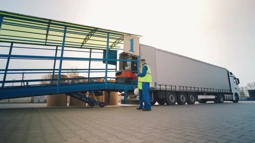 Forklift Unloading Packages into Semi Truck at Warehouse