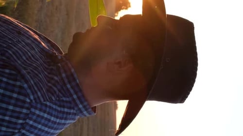 Man in Cowboy Hat Smiles in Corn Field at Sunrise