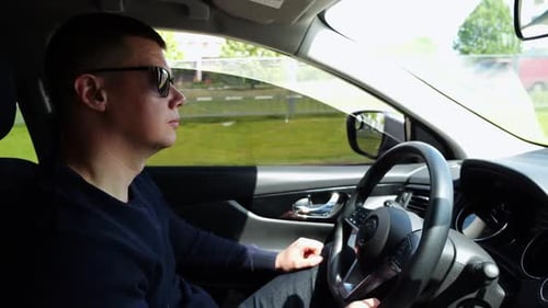 Serious Male Driver in Sunglasses Looking Concentrated to Urban Road While Riding Automobile Profile