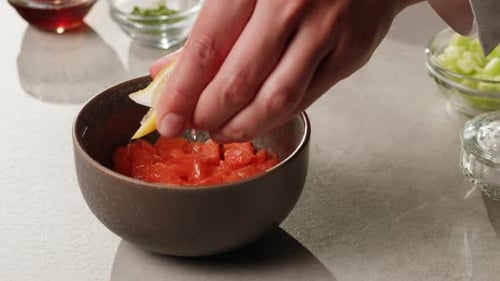 Chef Adding Fresh Lemon to Cut Salmon