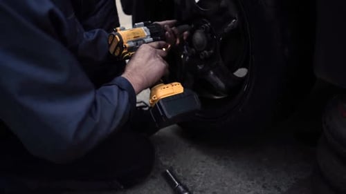 Mechanic Changing a Car Tire with Power Tool