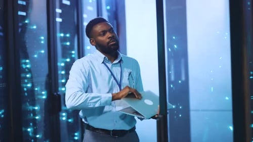 Man with Laptop Working in a Data Center