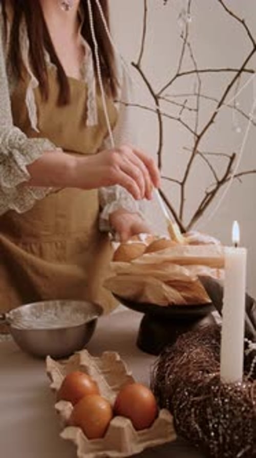 Woman Decorating Easter Bread with Powdered Sugar