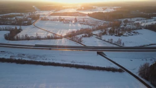Le coucher de soleil d'une beauté époustouflante qui projette sa lueur sur les champs enneigés Un paysage hivernal serein dans
