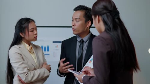 Three People Discussing Business in Office Workplace