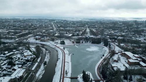 Drohnen-Winteraufnahmen. Gefrorener See im Stadtzentrum mit einem Fluss in der Nähe