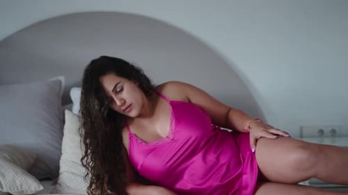 Pregnant Young Woman in Pink Nightgown Going to Sleep