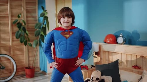 Boy Dressed as Superhero Poses in Bedroom