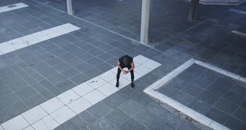 A handsome young man stretching during his jog out in the city