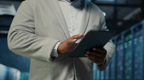 Data Center System Administrator Coding on Tablet Doing Software Updates